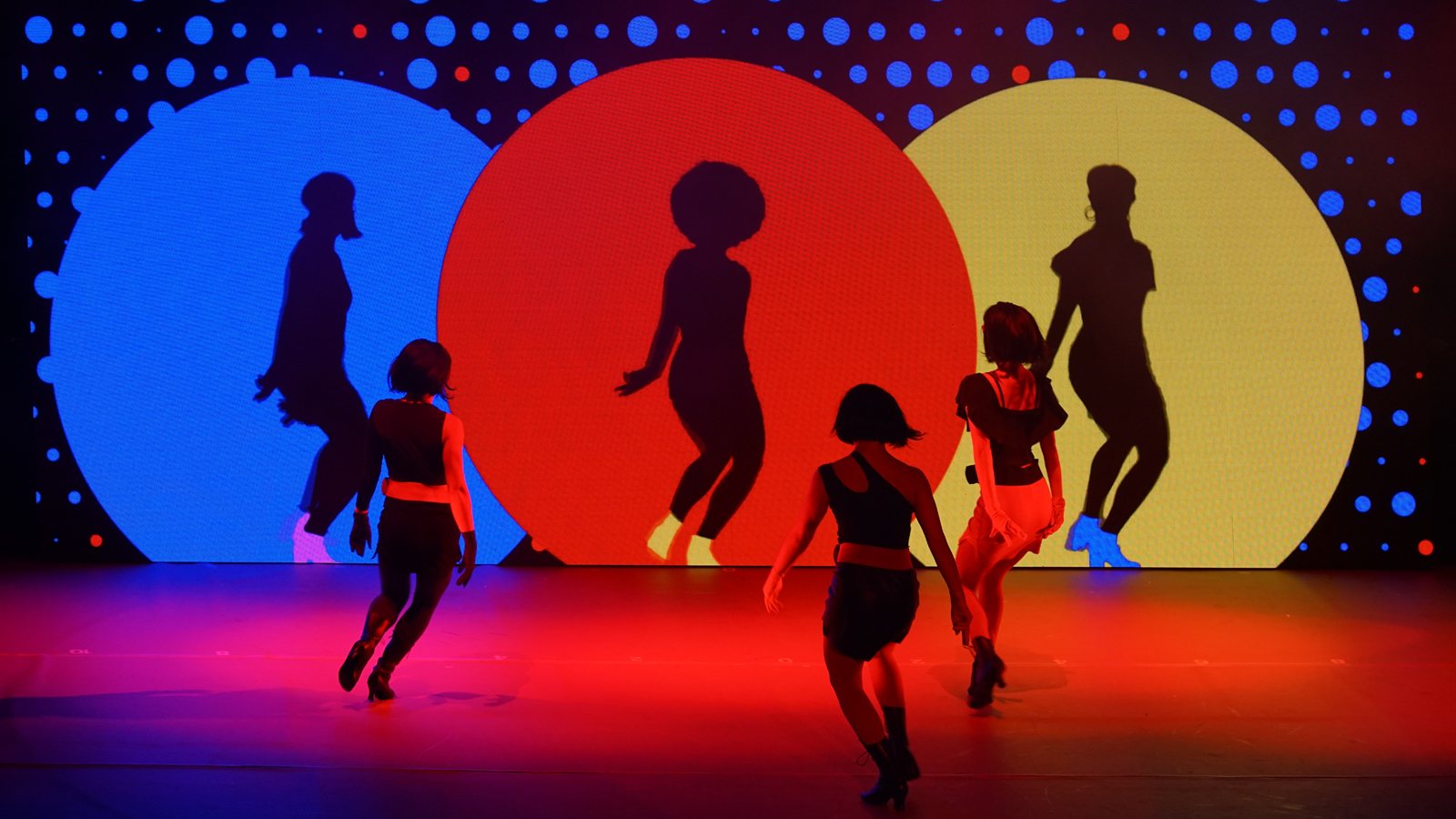 Dancers performing under stage lighting