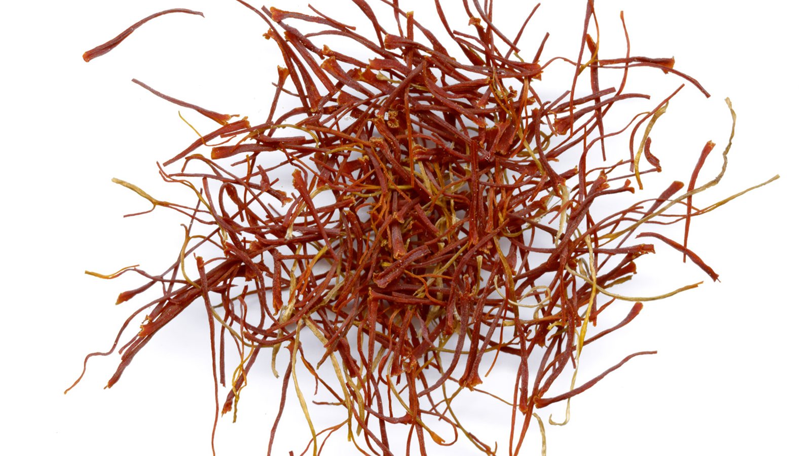 Loose red saffron threads on a white surface