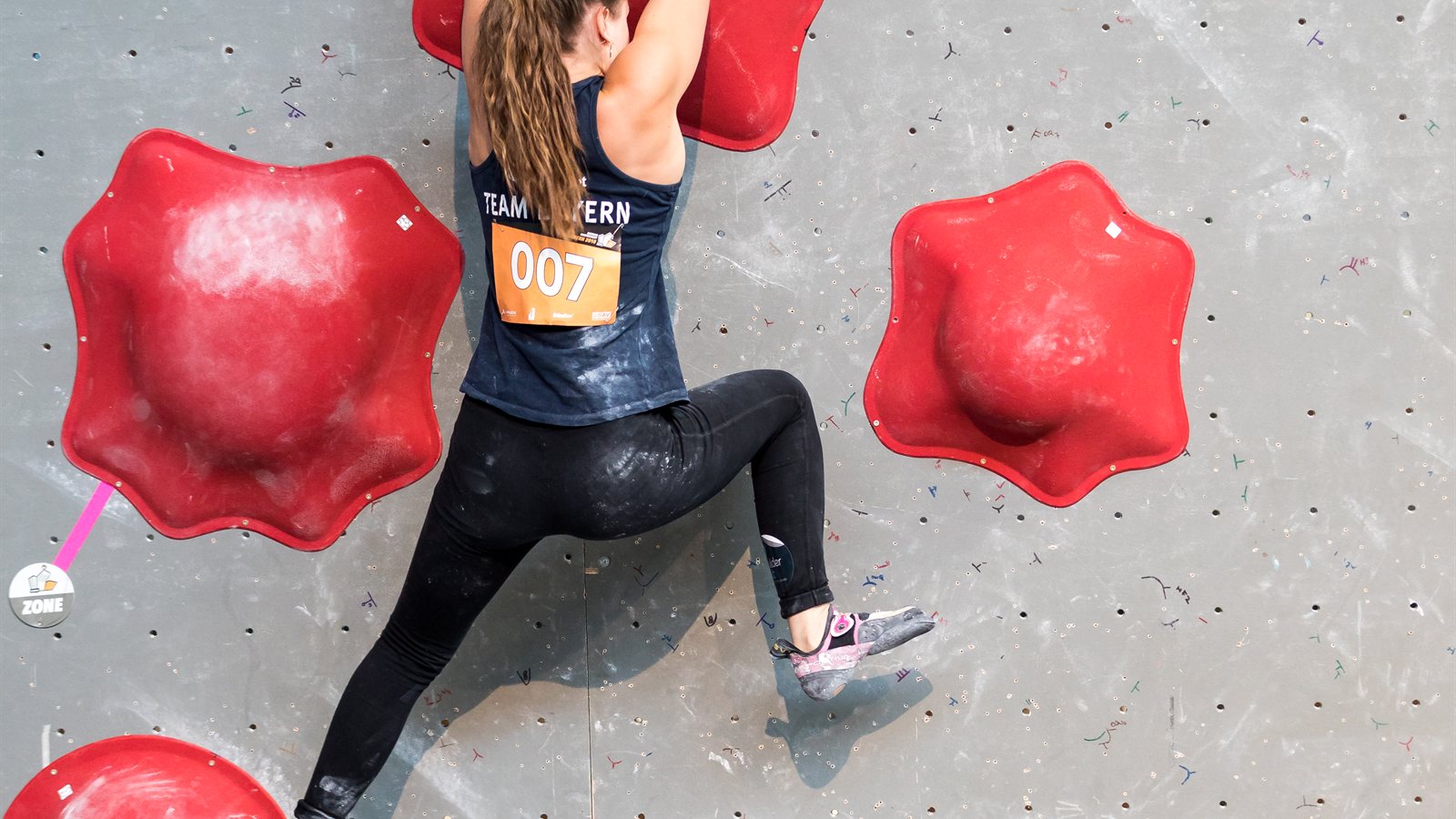 Boulderer working a problem on an outdoor wall