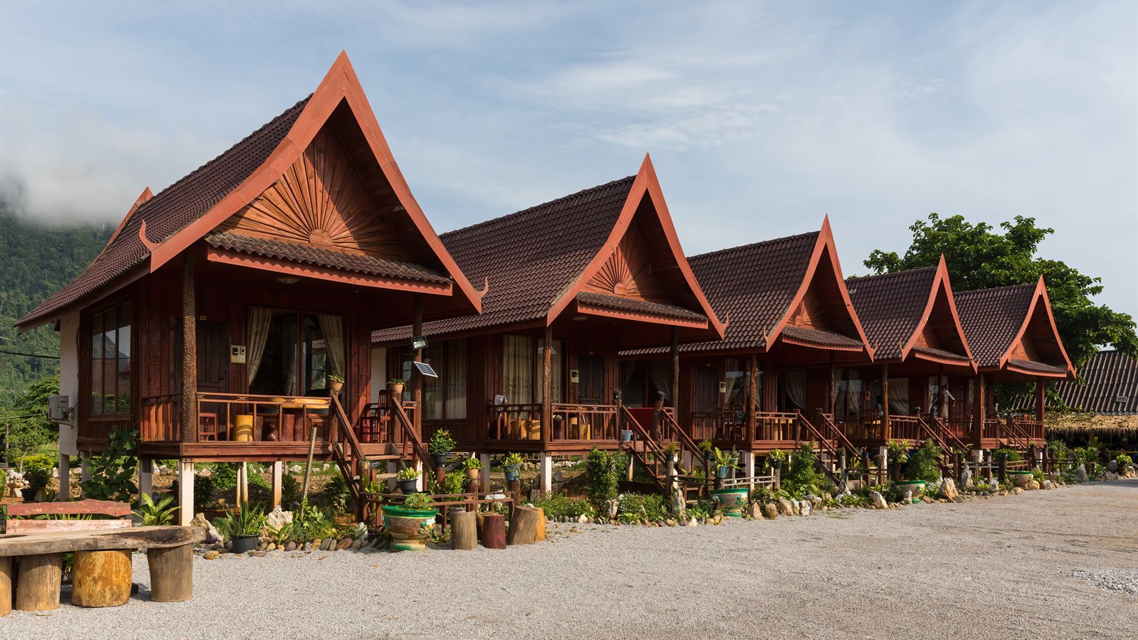 Row of timber bungalows with steep roofs and verandas