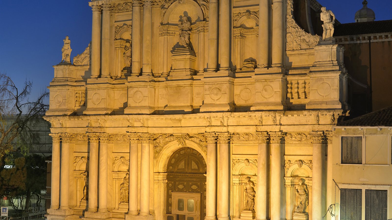 Illuminated historic church reflected in a canal at night