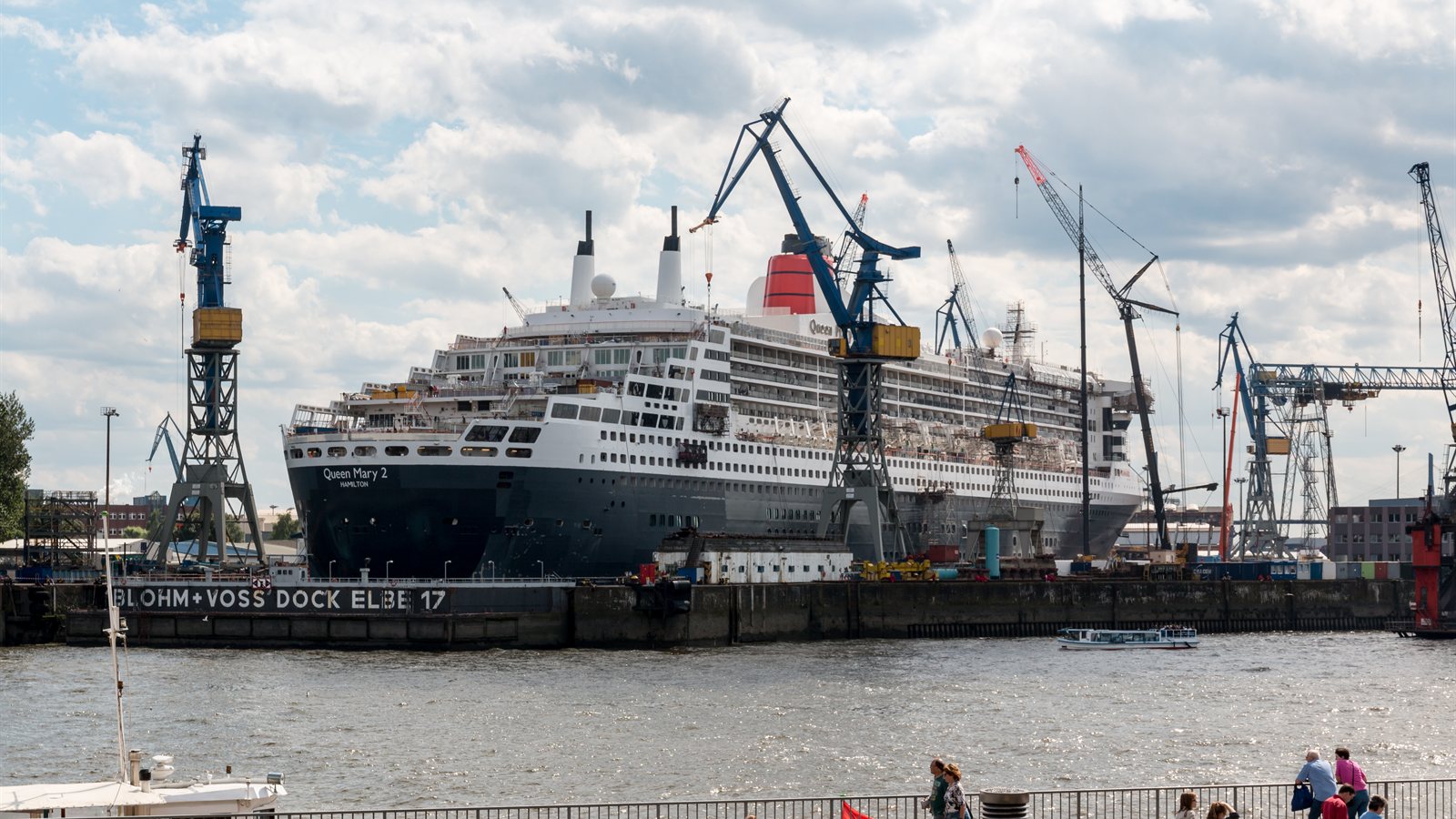 Large vessel in a dry dock surrounded by cranes