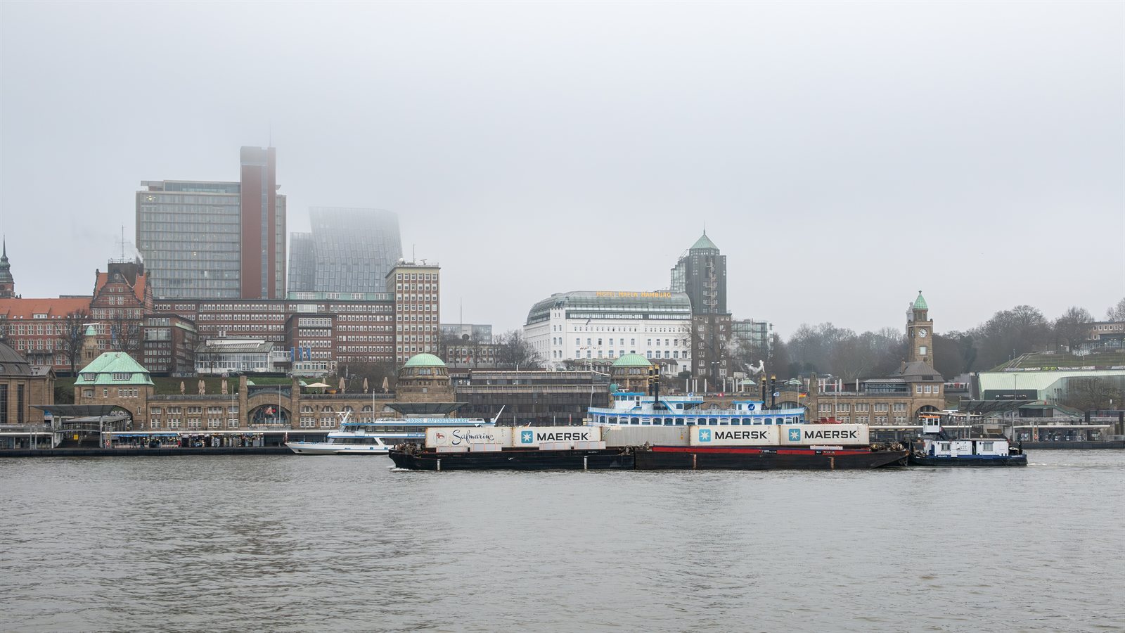 Harbour piers and moored vessels under a grey sky
