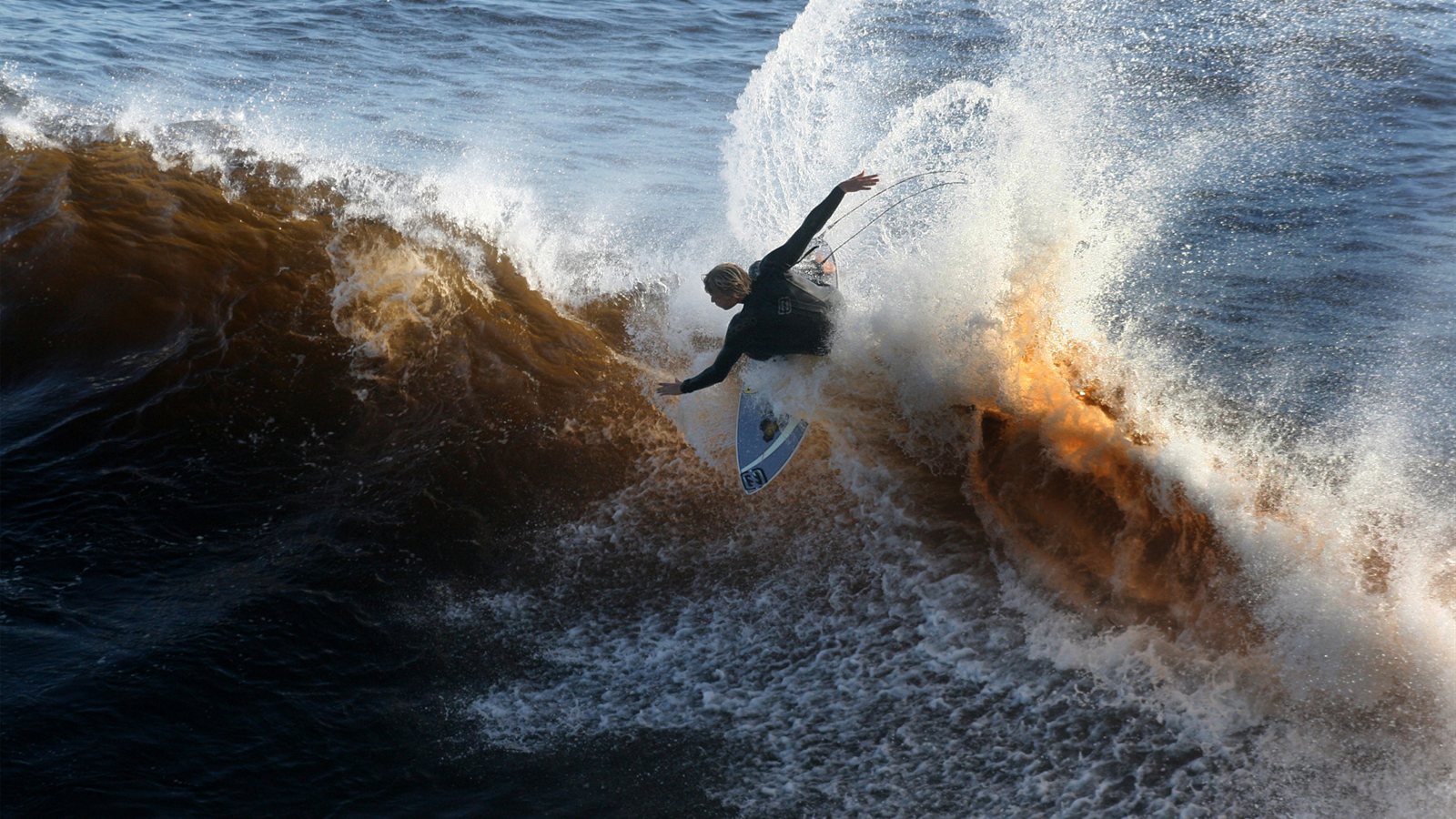 Surfer carving off the lip of a breaking wave