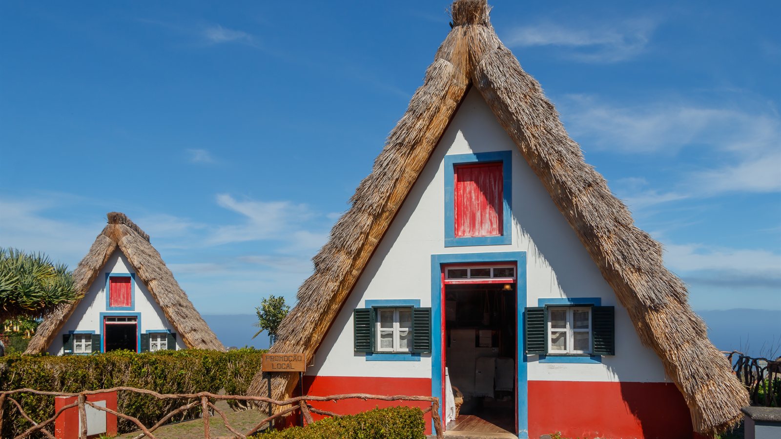 Traditional thatched cottages with painted shutters and hedged garden