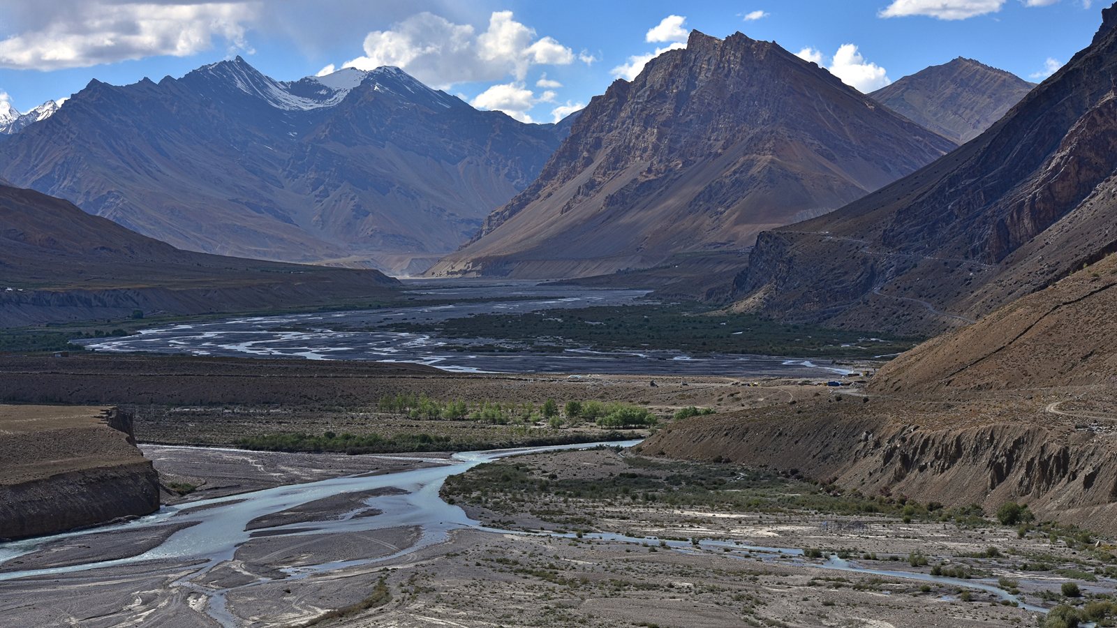 Wide braided river running through a bare mountain valley
