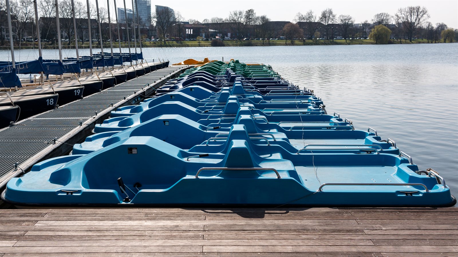 Row of hire boats tied along a wooden pontoon