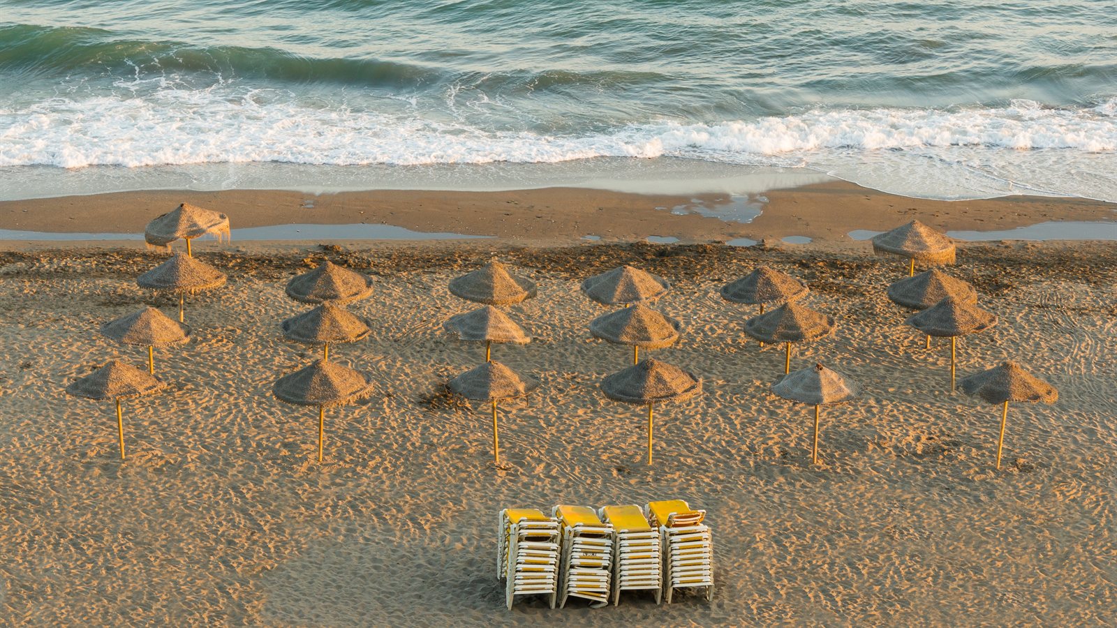 Mediterranean beach with parasols in evening light