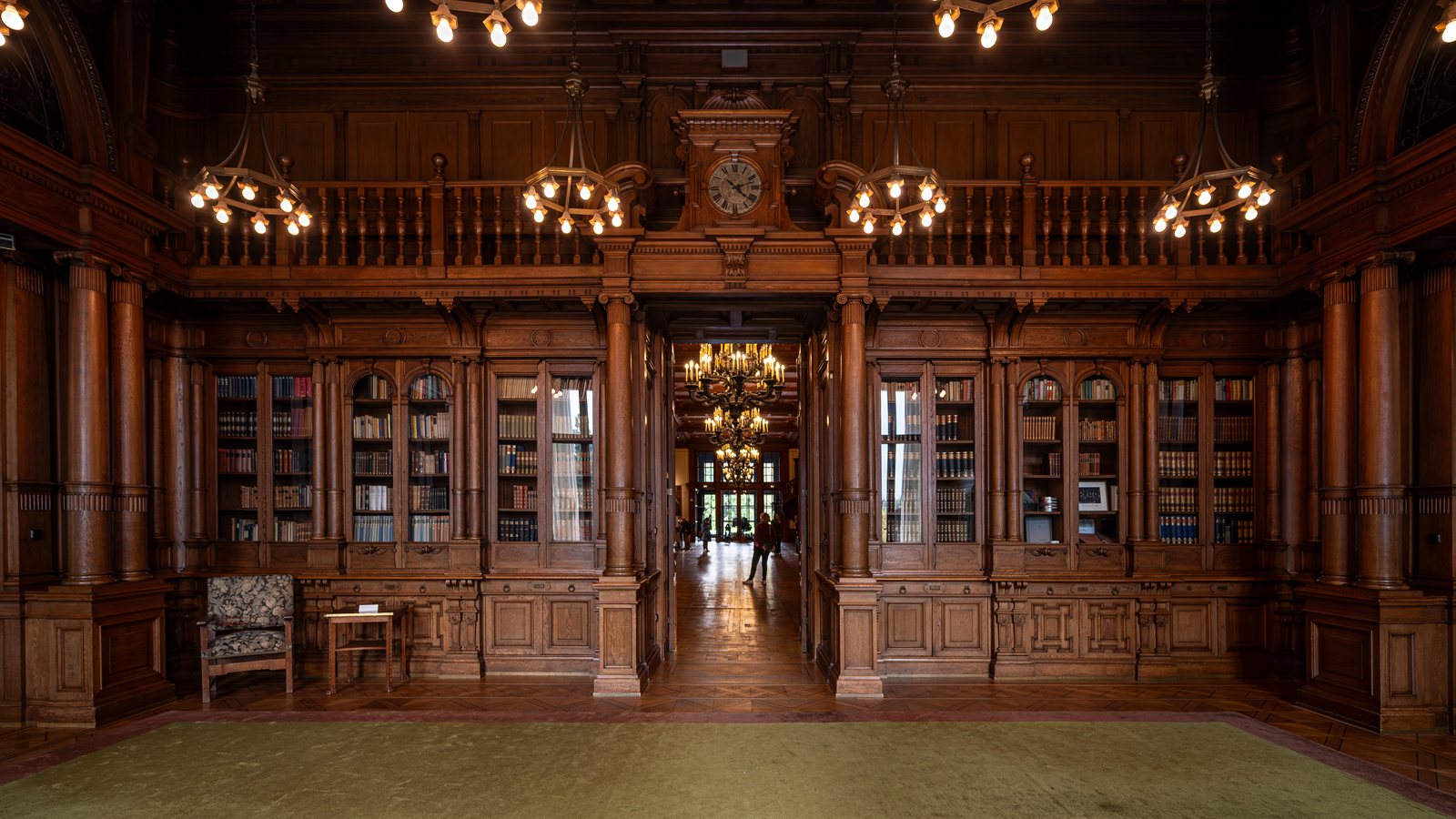 Panelled library room with tall bookcases in a historic villa